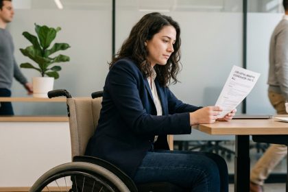 Jeune femme en fauteuil lisant une offre d'emploi dans un bureau moderne